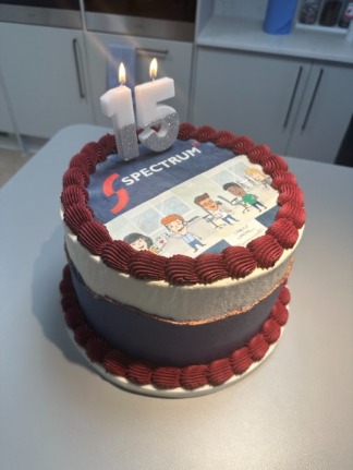 Spectrum IT logo cake, with candles in the shape of 15 lit 